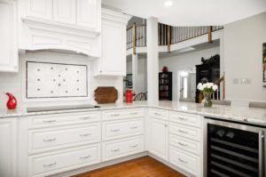 all white kitchen with wine cellar and undercabinet hood