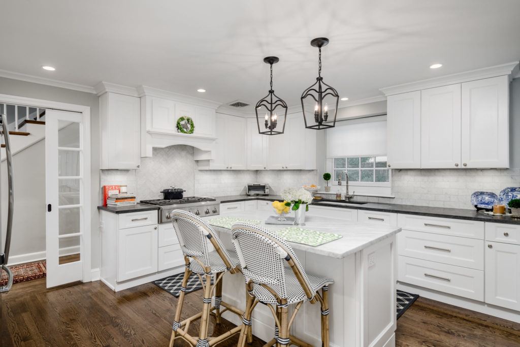 White L shape kitchen with small white island 