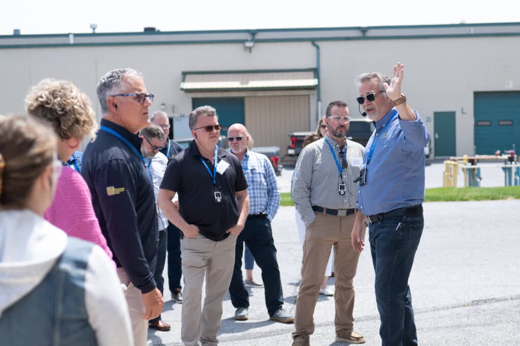 Main Line Kitchen Design's Chris Rossetti listens on Plain and Fancy Training Day one's afternoon factory tour