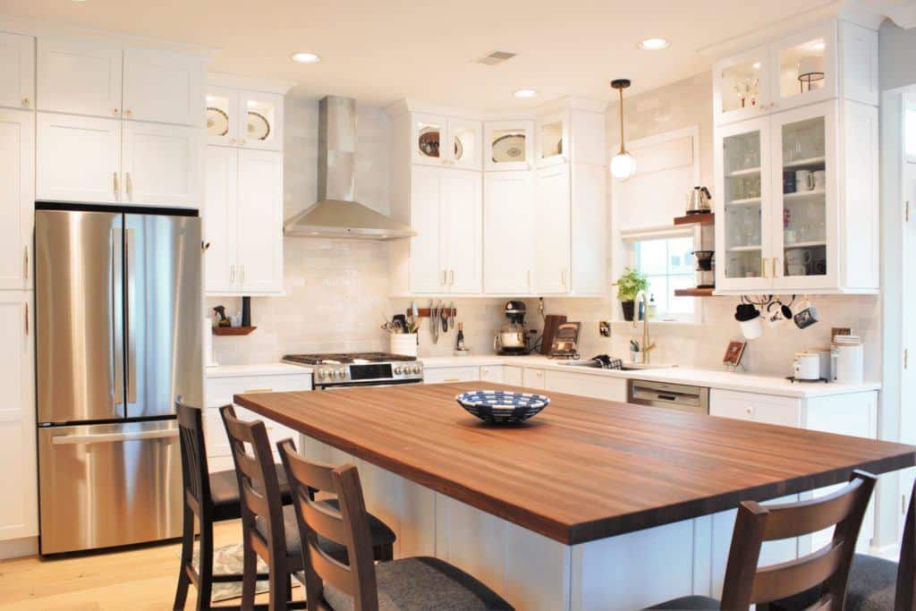 white kitchen and island with a wooden countertop