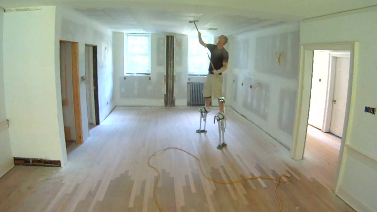 Man on stilts sands ceiling. This is how professionals do it. Most HGTV shows don't show this