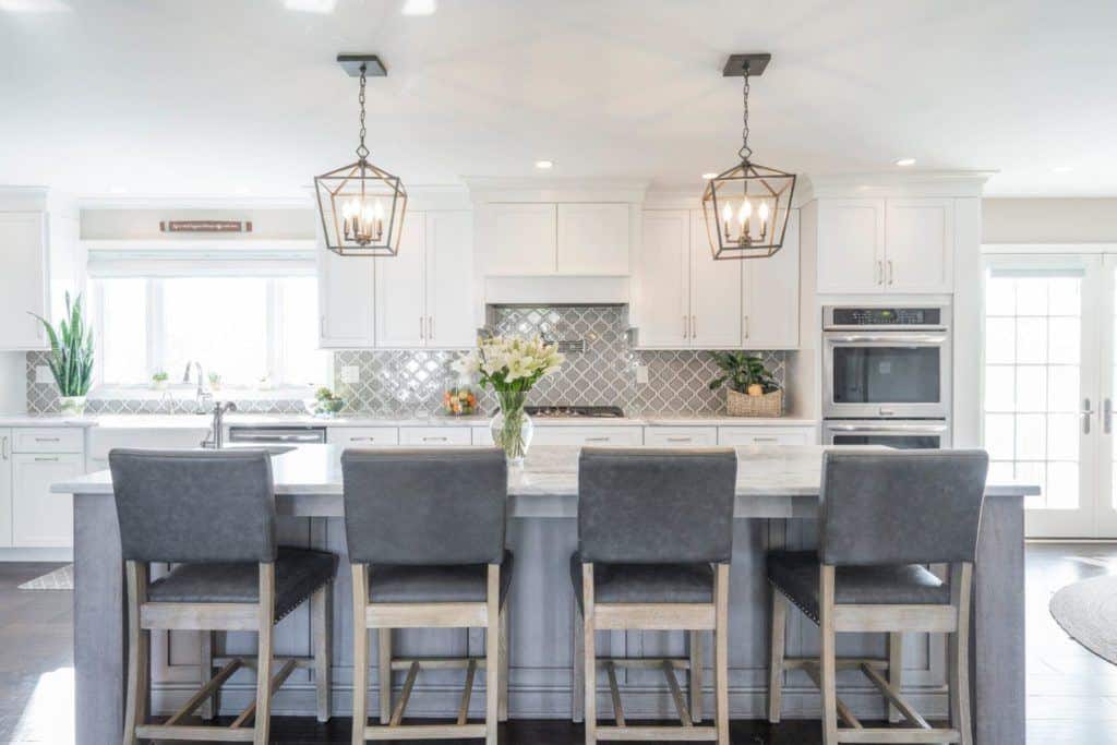 white kitchen with gray island and seating