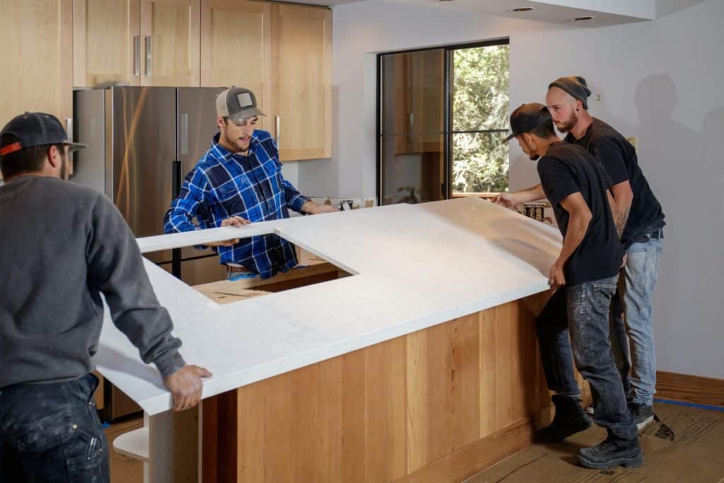 people installing a countertop onto an island
