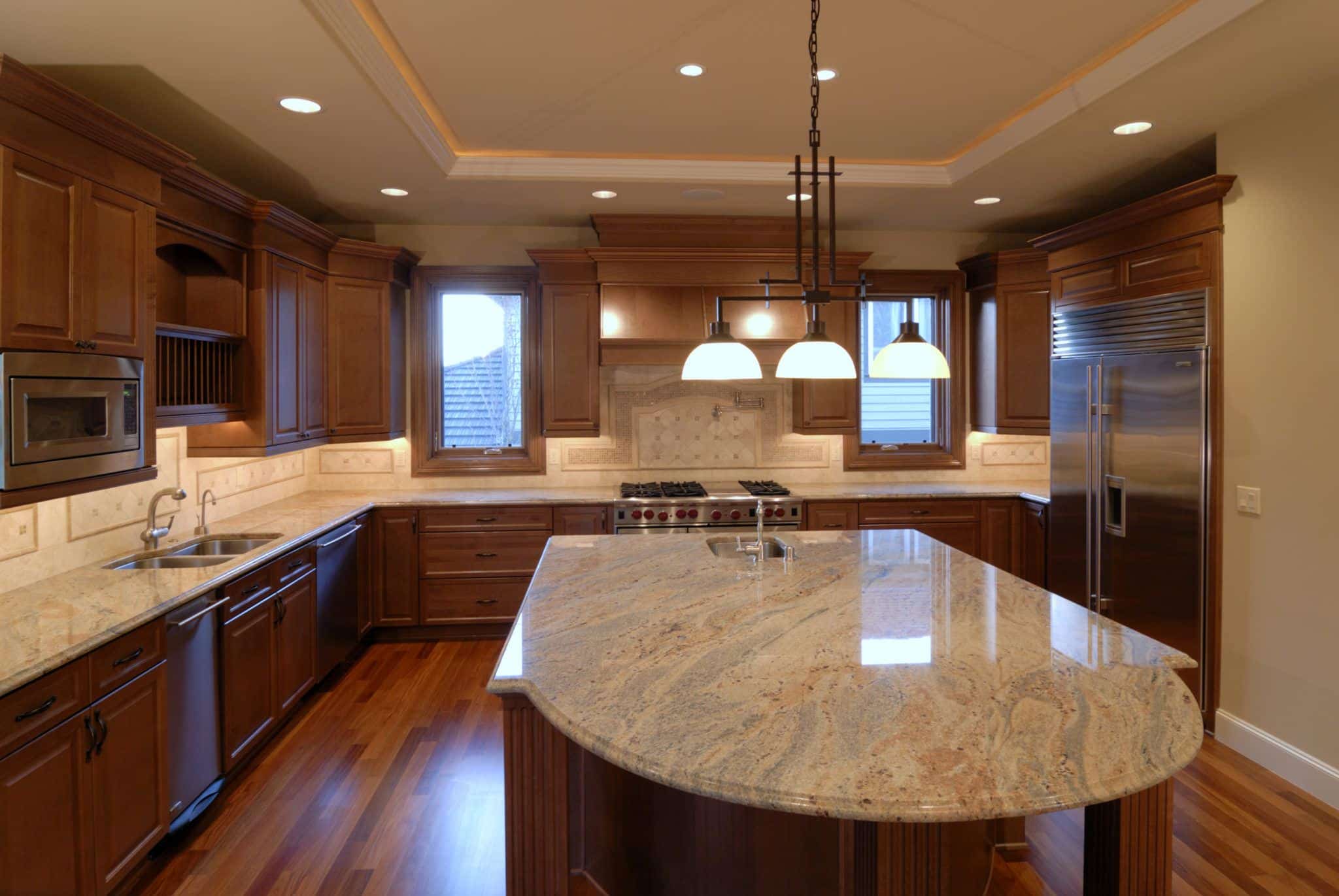Brown kitchen with island and radius corner countertop overhang