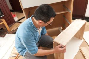 person assembling a cabinet