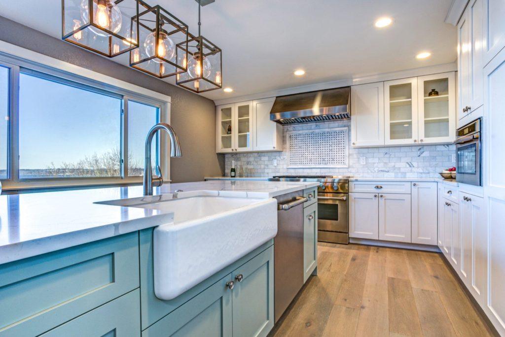 white kitchen with blue island This sink is not a fireclay farmhouse sink it is an apron front cast iron sink.