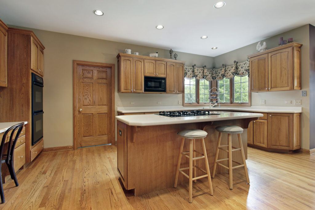 natural wood kitchen with island. Putting a wall cabinet above the door in the photo would be a design mistake